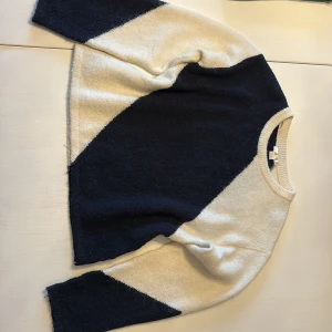 Blåvit stickad tröja med diagonal mönster - Snygg stickad tröja från Gina tricot i blått och vitt med ett diagonalt mönster. Rund hals och långärmad modell, perfekt för dig som gillar stilrena och grafiska plagg. Mjuk och skön kvalitet som håller dig varm under kyliga dagar.