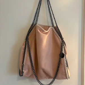 Rosa axelväska med kedjedetaljer - Fin rosa axelväska, stor och rymlig, många fack💕lite missfärgad på baksidan men inget man tänker på 