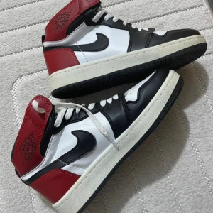 Nike Air Jordan svart/röd/vit - Säljer ett par Nike Air Jordan  sneakers i klassisk svart, röd och vit färg. 