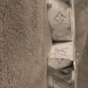 Vit bälte med monogram - Säljer ett vitt bälte med det klassiska monogrammönstret i lila. Bältet har en stilren design och är perfekt för dig som vill ha en exklusiv accessoar med tydlig logga. Passar till både jeans och kostymbyxor.