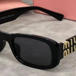 Svarta och leopardmönstrade Miu Miu solglasögon - Två par solglasögon från Miu Miu med rektangulär form och breda skalmar. Ena paret är helsvart med mörka linser, det andra har leopardmönster i brunt, gult och svart. Båda har en snygg guldfärgad Miu Miu-logga på skalmen. Perfekt för dig som vill sticka ut.