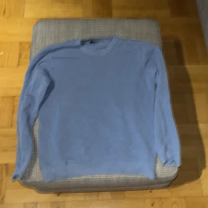 Ljusblå stickad tröja från Riley - Snygg ljusblå stickad tröja från Riley i storlek M.perfekt för dig som gillar enkel och stilren design. Denna tröja har bara testat men inte passat mig 