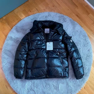 Moncler Maya Puffer Jacka - Svart Moncler Maya Puffer Jacka i storlek 3/M. Helt oanvänd.