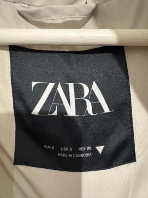 Vit pufferjacka från Zara med huva - Säljer en snygg vit pufferjacka från Zara i storlek S. Jackan har en stor, mysig huva och dragkedja framtill. Den är quiltad och har en loose passform som ger en chill vibe. Perfekt för kalla dagar och enkel att styla med dina favoritjeans.