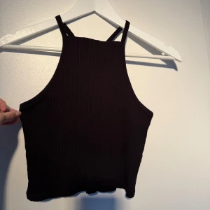 Linne - Svart ribbad halterneck top från Gina storlek m. Vita trådarna i nacken är från lappen på insidan
