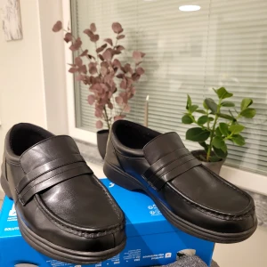 Svarta loafers från Dr. Scholl's 43 - Stilrena svarta loafers från Dr. Scholl's i skinn med klassisk design och platt sula. Skorna har rund tå och diskreta sömmar framtill, perfekt för dig som vill ha en enkel och bekväm sko med snygg look.