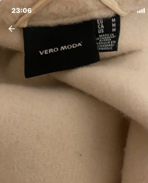 Beige teddyjacka från Vero Moda - Säljer en beige teddyjacka från Vero Moda i storlek M.  stora fickor framtill och klassisk krage. Materialet är mjukt. Stängs med knappar framtill och har långa ärmar.