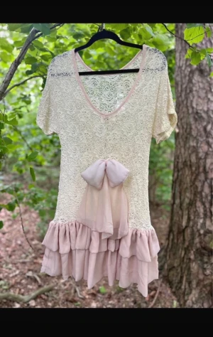 Ester Elenora Klänning - Ny med lapp!  Storlek One Size passa bäst S-M  Rosetten är baktill  Färg ros/ champagne.