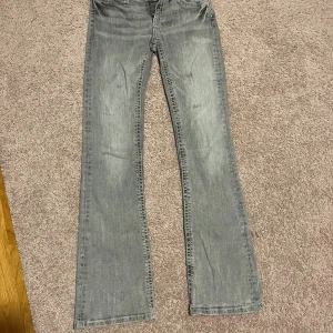 Grå bootcut jeans från Gina Tricot  - Snygga grå jeans från Gina Tricot med bootcut passform och kontrasterande vit söm på bakfickorna. Strl 164