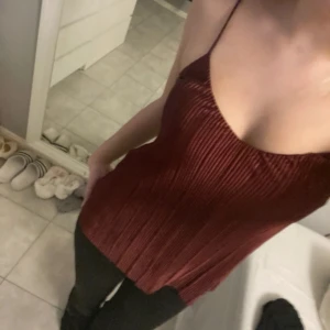 Vinröd plisserad linnetopp - Säljer en vinröd linnetopp med tunna axelband och snygg plisserad struktur. Toppen har en tight passform upptill och faller lite lösare nedtill. Perfekt för dig som gillar stilrena detaljer och en djupare färgton.