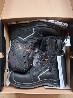 Svarta vinterstövlar Gesto Tor strl 38 - Svarta vinterstövlar från Gesto, modell Tor, med grov sula och snörning. Insidan är fodrad med mjuk svart päls för extra värme. Yttermaterialet är slitstarkt syntet och skinn, med detaljer i grått och orange. Perfekt för kalla dagar och tuffa förhållanden.... ny pris 1700