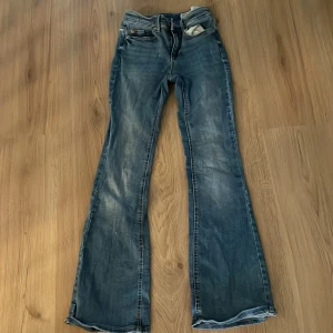 Blå bootcut jeans från Vero Moda - Snygga blå jeans från Vero Moda med klassisk bootcut-passform och slitningar för en cool look.  Lowwaist och knappt använda. Skriv om ni har några frågor💕