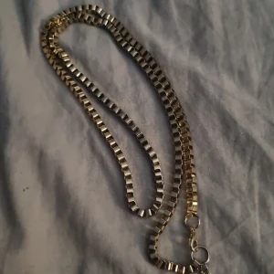 Guldigt boxkedje-halsband - Snyggt halsband med boxkedja i guldtonad metall. Kedjan har en fyrkantig, geometrisk design som ger ett coolt och stilrent intryck. Perfekt för dig som gillar minimalistiska smycken med lite edge. Längden är klassisk och passar till de flesta outfits.
