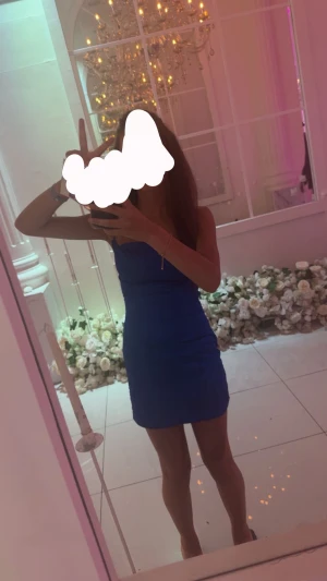 Blå kort klänning med smala axelband - Säljer en snygg blå kort klänning som använts 1 gång med smala axelband och figurnära passform. Klänningen har en enkel och stilren design som framhäver siluetten. Perfekt för dig som vill sticka ut med en färgstark look.