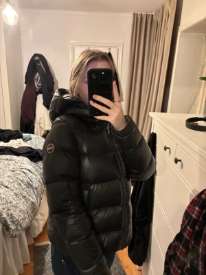 Svart pufferjacka från Colmar - Säljer en svart vinterjacka från Colmar med luva  och dragkedja. Perfekt för dig som vill ha en varm och snygg look under kalla dagar. Märke syns på ärmen. Kan tänka mig att sälja för 2500 vid snabb affär💞
