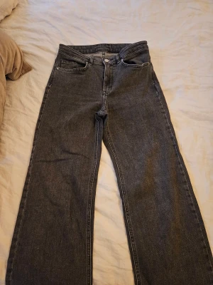 Mörkgrå wide jeans från C.W. - Snygga mörkgrå jeans från C.W. med klassisk femficksdesign och breda ben. Jeansen har mellanhög midja och raka sömmar, tillverkade i robust denim. Perfekta för dig som gillar en avslappnad och trendig look.