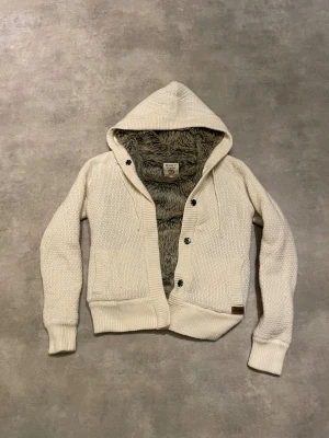 Stickad cardigan med päls  - Stickad huvtröja cardigan med päls . Storlek Xl men passar  bra som är runt 170-180. Uppskattad storlek m/s. 