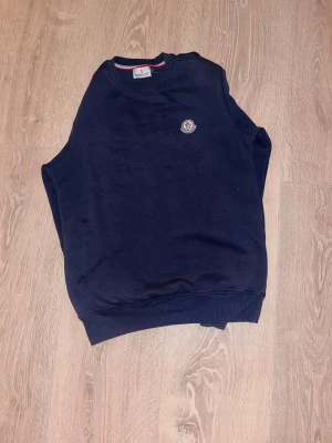En mörkblå moncler tröja.skriv prisförslag - En snygg och simpel moncler tröja som är storlek s men passar m ganska bra.tröjan har ett litet hål vid armhålan men de är inget som syns.skriv prisförslag 