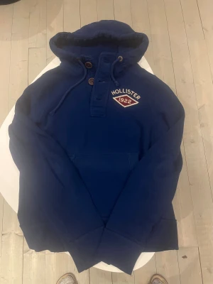Hollister California hoodie mörkblå  - Hollister California mörkblå hoodie sällsynt. Storlek S/M passar 169-179 cm lång I perfekt skick inga defekter och väldigt skönt material och varm.Pris 568 kr ej hugget i sten kolla gärna in mina andra annonser för mer och rabatt 😃