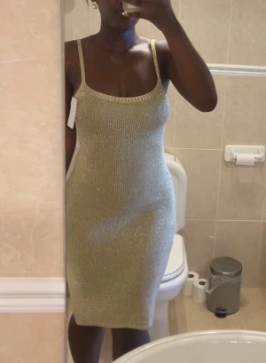 Glittrig guldig bodycon klänning - Öppen rugg med knyt, helt oanvänd! Strl xs/s