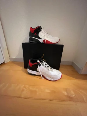 Nike Jordan 3  sneakers vit/röd/svart - Säljer ett par Nike Jordan sneakers med klassisk Jumpman-logga på sidan och siffran 23 på plösen. Skorna är vita med svarta och röda detaljer, har snörning och en platt sula. Ovandelen är i skinn och mesh för extra komfort och stil. Perfekt för dig som gillar basketinspirerad streetwear.