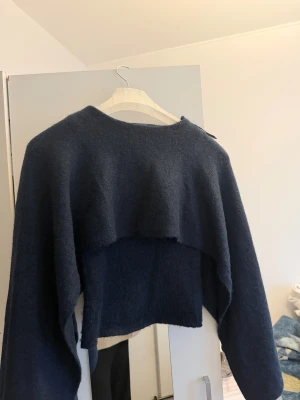 Trendig cape stickad tröja - Strl 34 XS. Aldrig använd. Har inge nopprar. Material m: akryl, ull, viskos , ord pris 399kr