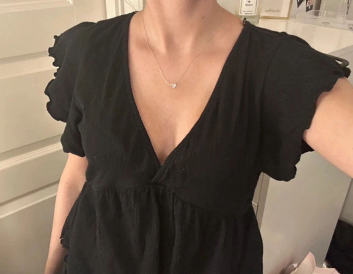 Svart blus med volangärm och knyt