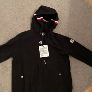 Moncler vindjacka  - Svart Moncler Windbreaker. Storlek 1 (Motsvarar S). NFC scan fungerar. Tar ej emot byten och priset går tyvärr ej att diskuteras. Fråga gärna för fler bilder eller funderingar.