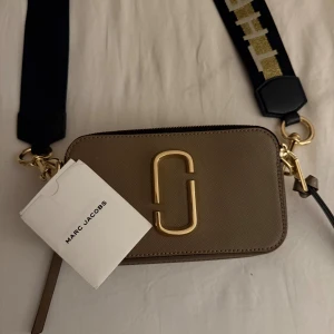 Beige väska - Beige Marc Jacobs väska med guld detaljer på banden 