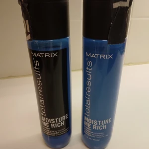 Matrix Moisture Me Rich duo schampo, balsam. - Två flaskor Matrix Total Results Moisture Me Rich, en schampo och en balsam, båda med svart lock och blå flaska. Innehåller glycerin för extra återfuktning och passar torrt hår. Modern design med tydlig vit text på framsidan. 300 ml per flaska. Köpta på Lyko. Har stått en tid men är helt oanvända. 