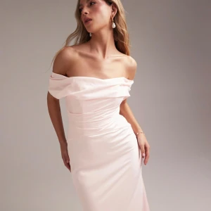 Balklänning - Superfin ljusrosa långklänning i satin med offshoulder och draperad överdel. Klänningen har figurnära passform och markerad midja, perfekt för bal eller student. Materialet är glansigt och ger en lyxig känsla. Säljer pga att jag inte längre behöver den. Har lite fläckar längst ner som ej gick bort i tvätt men skulle inte säga att det syns när den är på.