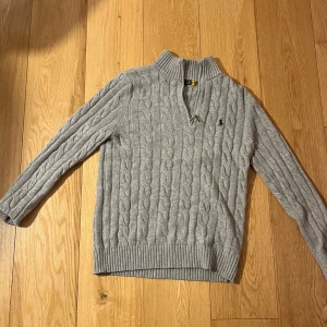 Ralph Lauren half zip grå - Snygg grå kabelstickad tröja från Ralph Lauren. Storlek M men passar S den är ganska slimfit. Skriv om ni skulle ha några fler funderingar 