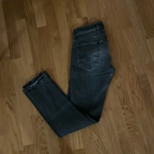 Replay Grover svarta/gråa jeans, stl 30 - Svarta/gråa Replay Grover jeans med snygga detaljer på bakfickorna. Modellen har en rak passform och klassisk femficksdesign. Jeansen är tillverkade i slitstarkt denim och har en mörk tvätt som ger en cool vibe. Perfekt för dig som gillar stilrena och tidlösa jeans. W30 L32 hör av dig vid några frågor