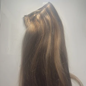 Löshår - Säljer ett set med långt löshår i mixade bruna och blonda nyanser. Håret är rakt och har en naturlig glans. Fästet är en tunn weft med tråd för enkel applicering.