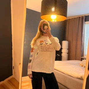 Vit långärmad Adidas tröja med blommor - Säljer en vit långärmad tröja från Adidas med coolt tryck 'Always Original' och färgglada blommor på bröstet och ärmarna. Tröjan har rund hals och är gjord i mjuk bomull. Perfekt för dig som gillar streetstyle och vill sticka ut med snygga detaljer.