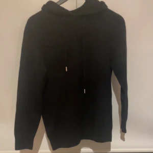 Merinoull svart - Helt oanvänd!!!Svart merinoull hoodie med huva och snörning i halsen. Tröjan har lång ärm och en klassisk, enkel design utan synliga loggor eller mönster. Perfekt för dig som gillar stilrena, grischiga bekväma plagg. Materialet känns mjukt och passar bra till chill dagar speciellt nu till kallare perioder! Skriv vid frågor 