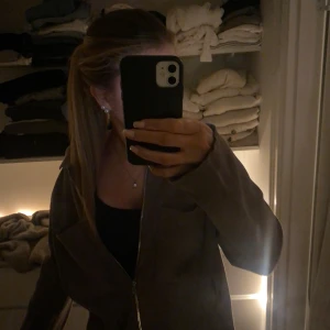 Brun kofta från Åhléns  - Säljer en brun stickad overshirt/kofta med dragkedja framtill och två stora fickor fram. Jackan har klassisk krage och är långärmad, en enkel och stilren design. Den är använd någon enstaka gång och har inga defekter alls. 