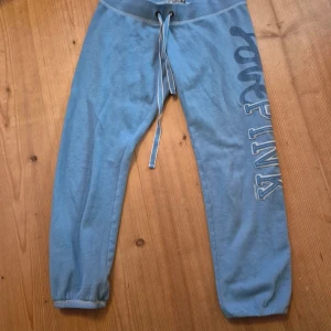 Blå mjukisbyxor från PINK Victoria's secret  - Blå mjukisbyxor från PINK by Victoria's Secret i storlek S. Byxorna har snörning i midjan, resår vid bensluten och ett stort tryck med texten PINK längs ena benet. Mjukt material som är skönt att ha på sig. Perfekt för chill eller träning.