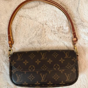 Louis Vuitton monogram axelväska - Snygg axelväska från Louis Vuitton i klassiskt monogrammönster. Väskan är brun med ljusbruna detaljer och guldfärgade metalldelar. Tillverkad i skinn med justerbar axelrem och innerfack med dragkedja. Perfekt för dig som vill ha en ikonisk och trendig accessoar. Har ingen box eller påse. Kvitto finns 