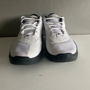 Nike GT Cut Academy vita sneakers - Nike GT Cut Academy sneakers i vitt med svarta detaljer och klassisk swoosh-logga. Skorna har snörning, meshpaneler för andning och en platt sula. Perfekta för dig som gillar sportig stil och vill ha bekväma skor till träning eller vardag. Går att prata pris