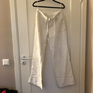 Vita linnebyxor från bpc, strl 36 - Snygga vita linnebyxor från bpc bonprix collection i storlek 36. Byxorna har snörning i midjan, raka ben och bakfickor. Perfekta för en chill och fräsch look under varmare dagar. Materialet är linne som ger en skön och luftig känsla.