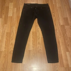 Svarta skinny jeans från Dsquared2 - Snygga svarta jeans från Dsquared2 med skinny passform och klassisk femficksdesign. Byxorna har diskreta slitningar framtill och en läderpatch med 'ICON' på baksidan. Materialet är stretchigt jeans för en tajt och bekväm känsla.