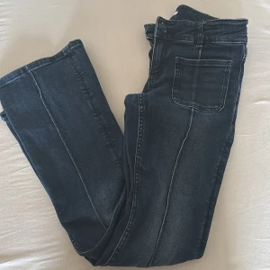 Blå bootcut jeans från Gina Tricot - Säljer dessa Snygga blå jeans i low waist  från Gina Tricot i storlek 158 med bootcut-ben och coola framfickor eftersom de har blivit för korta på mig som jag e då 164! . Jeansen har justerbar midja med knappresår och klassisk dragkedja. Materialet är jeans med en mörk tvätt och markerade sömmar framtill.