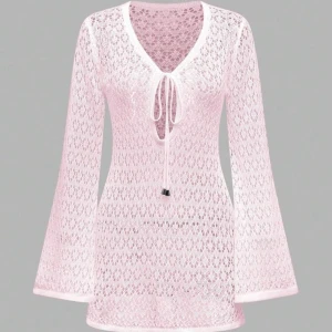 Ljusrosa strandklänning - Säljer en ljusrosa blus i spets med långärmade trumpetärmar och v-ringad hals. Toppen har snygg snörning framtill och är transparent med ett romantiskt mönster. Aldrig använd!🩷