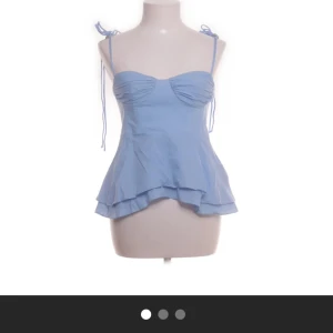 Ljusblå linnetopp från Zara XS - Supersöt ljusblå linnetopp från Zara med tunna axelband som knyts på axlarna. Materialet är lätt och känns som bomull, perfekt för varma dagar. Säljer då den inte kommer till användning.