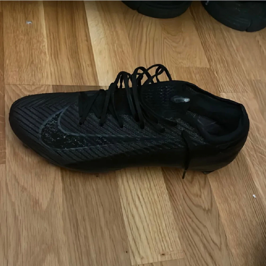 Svarta Nike fotbollsskor med snörning