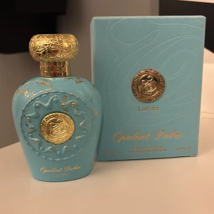 Lattafa Opulent Dubai EdP 100ml - Snygg och lyxig parfym från Lattafa, Opulent Dubai. Eau de Parfum i en unik blå flaska med gulddetaljer. Oanvänd då jag tyckte den var för söt