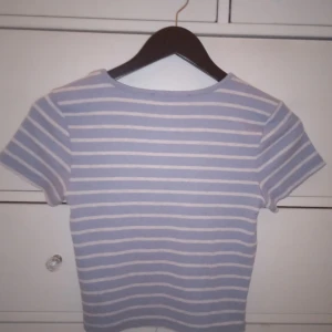 Randig kortare t-shirt  - En blå/vit randig t-shirt som är kortare än en vanlig t-shirt alltså croppad 