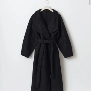 lång kappa med bälte - Snygg marin blå kappa med oversized krage och knytskärp i midjan. Lång modell som går ner mot vaderna och har en mjuk, lite fluffig yta. Perfekt för kalla dagar och ger en cool, avslappnad vibe till din outfit.