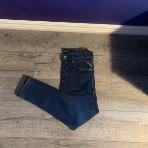 Replay hyperflex mörkblå jeans - Mörkblå Slim Fit Jeans – Stilrena & mångsidiga Klassiska mörkblå jeans i slim fit-modell, perfekta både till vardags och fest. Jeansen har en ren design med fem fickor, dragkedja och knappstängning. Sköna att bära tack vare en stretchig passform som sitter snyggt längs benen.  ✔️ Tidlös mörkblå färg ✔️ Slim fit – smal passform ✔️ Bekväma med stretch  I fint skick och redo för en ny ägare!